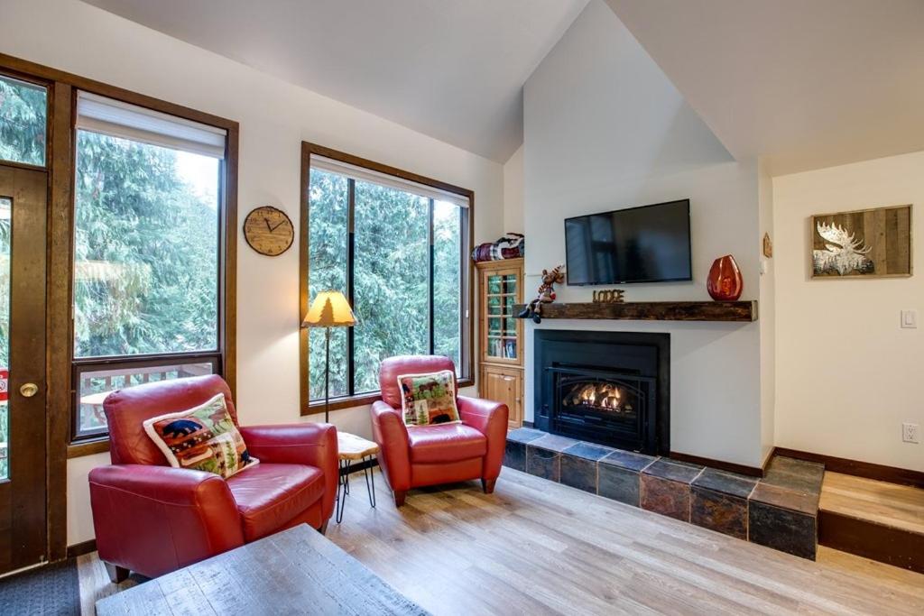 ein Wohnzimmer mit 2 Stühlen und einem Kamin in der Unterkunft 06SW - Fireplace - WithD - Kitchen - Sleeps 7 home in Glacier