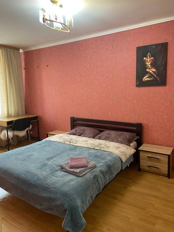 a bedroom with a bed and a red wall at Apartment in Shoduar's park in Zhytomyr