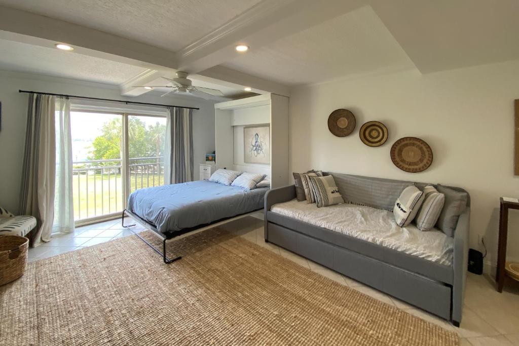 a bedroom with a bed and a couch and a window at Bluff Villas 1807 in Hilton Head Island