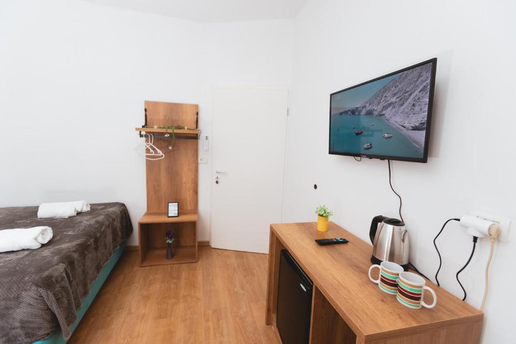 een kamer met een bed en een tv aan de muur bij Hotel Tier Center in Tirana