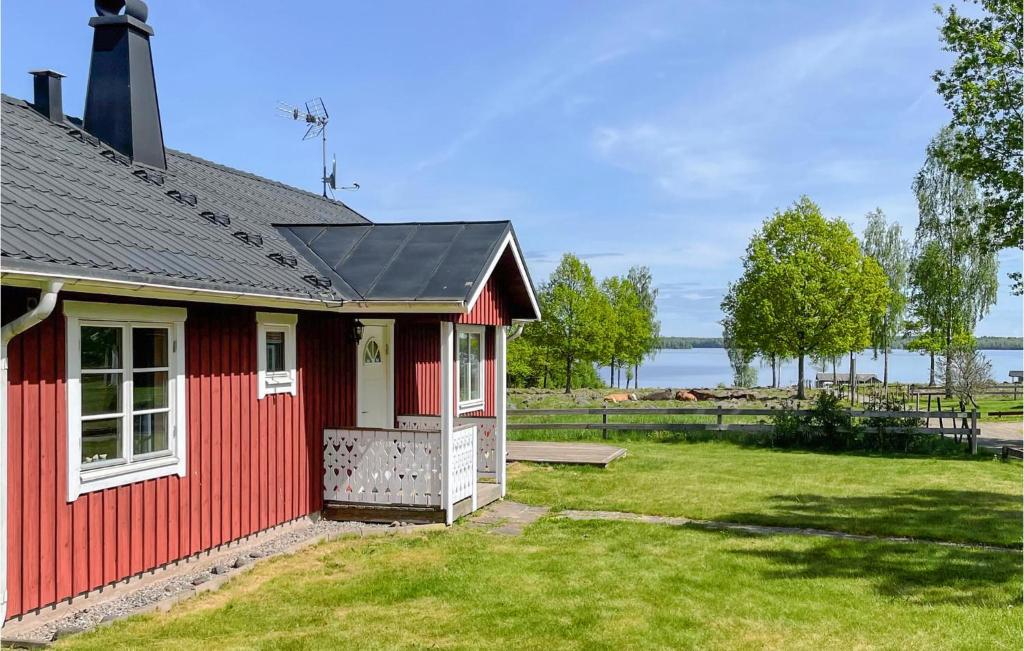una piccola casa rossa con un prato di Nice Home In Vittaryd With 2 Bedrooms And Wifi a Kvänarp