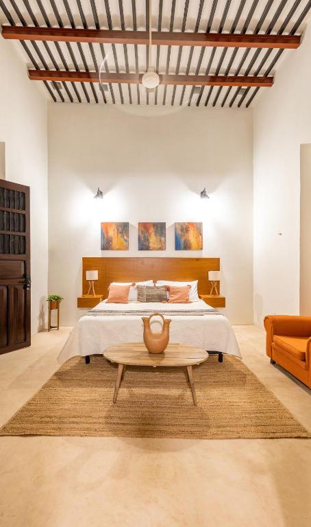 a bedroom with a large bed and a table at Casa Dos Lirios Hotel Boutique in Mérida