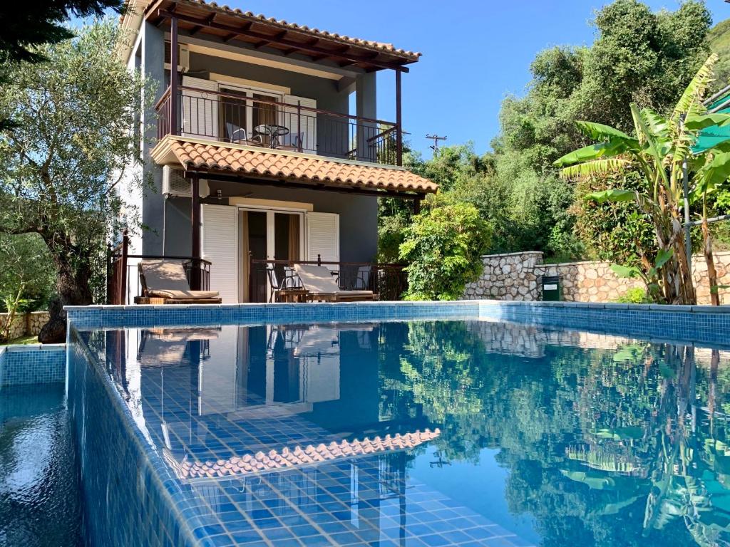 a villa with a swimming pool in front of a house at Dimarion Villas in Agios Nikitas