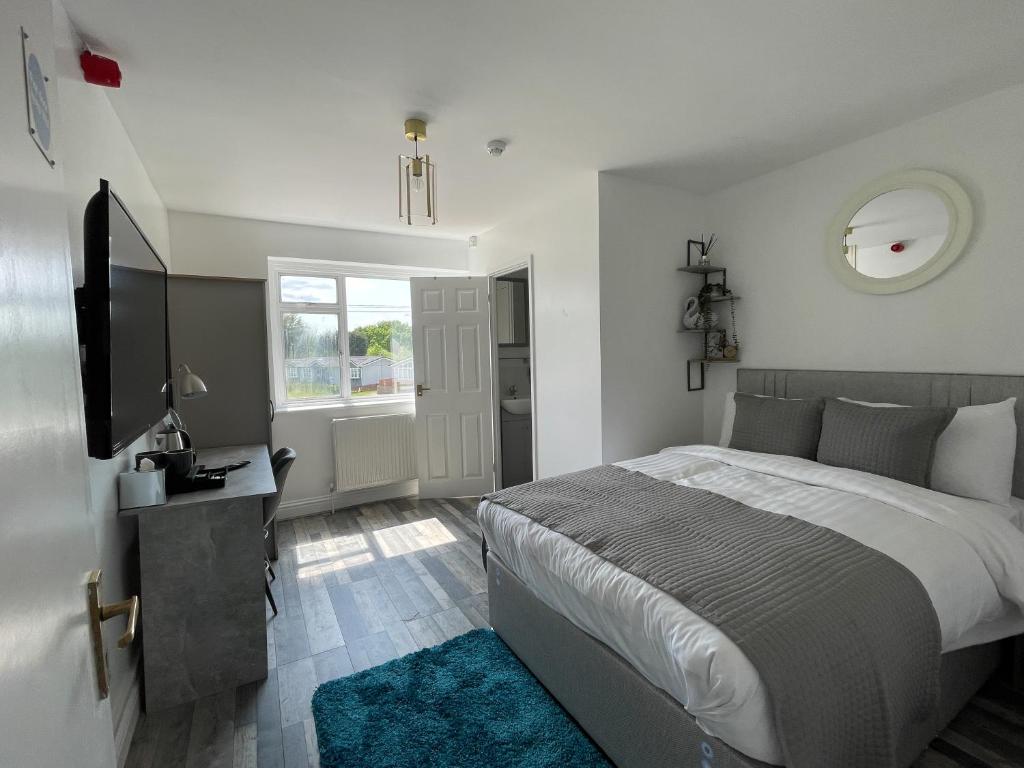 a bedroom with a large bed and a television at Isabella Rooms in Hockley