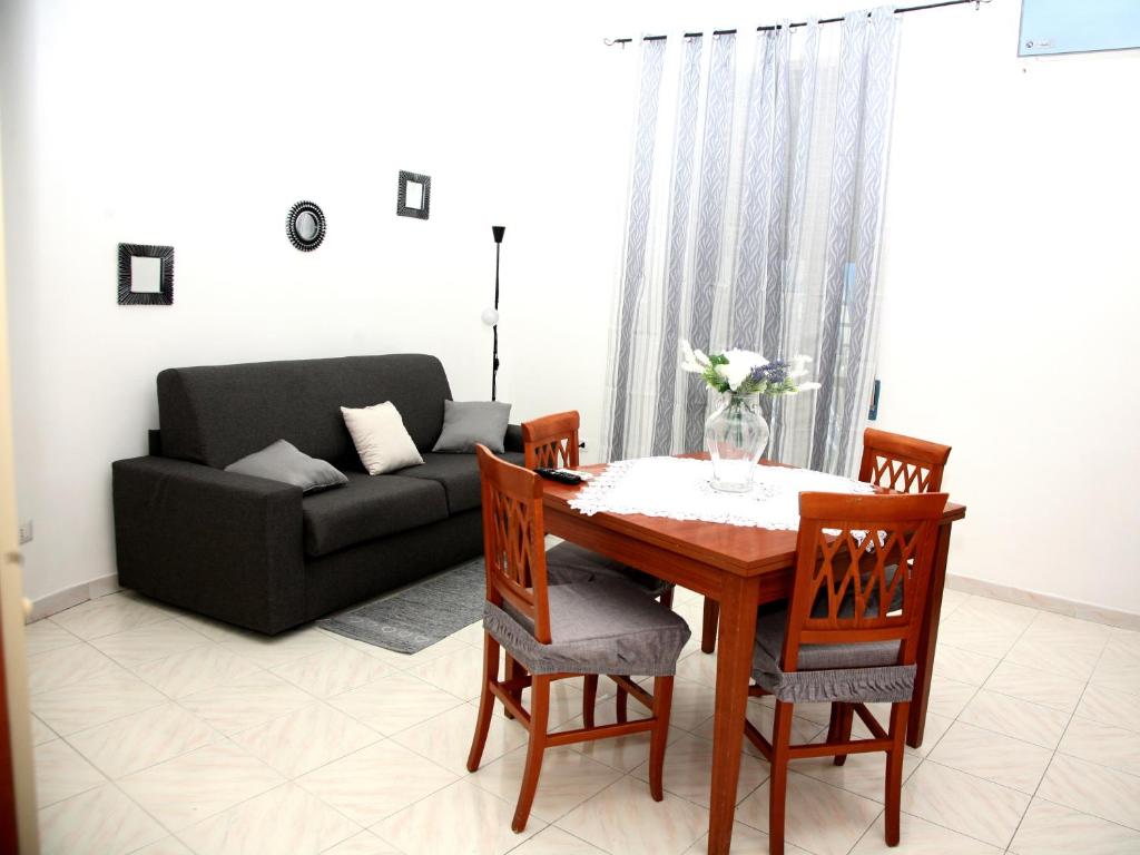 ein Wohnzimmer mit einem Tisch, Stühlen und einem Sofa in der Unterkunft Malì Casa Vacanze in Neapel