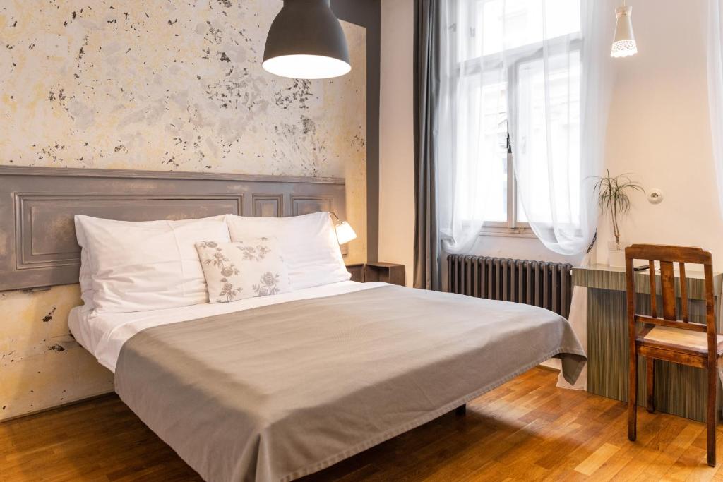 um quarto com uma cama com uma grande cabeceira e uma janela em Miss Sophie's New Town & Wellness em Praga