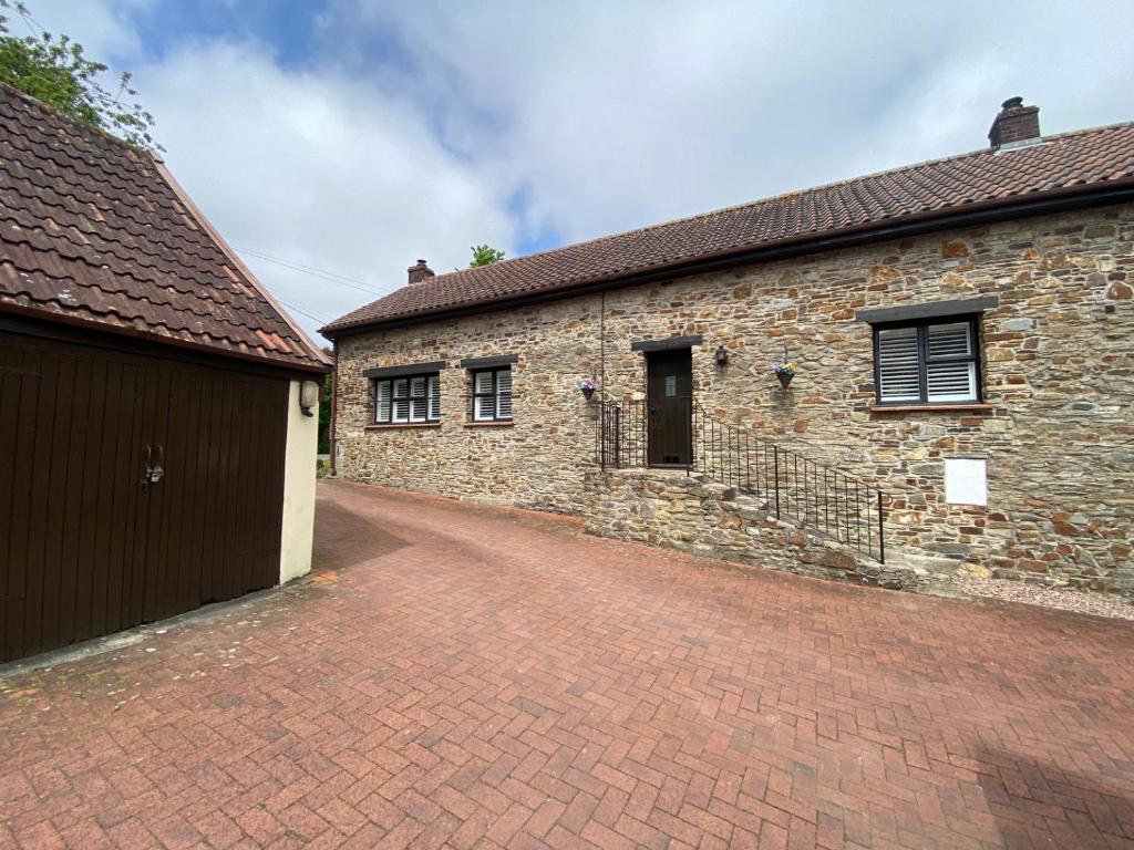 an old brick building with a brick driveway at 1 Old Farm Court in Barnstaple