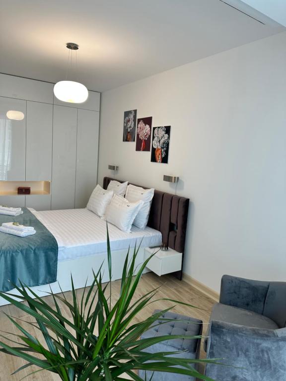 a bedroom with a bed and a potted plant at Jo Residence Mamaia Nord in Mamaia Nord
