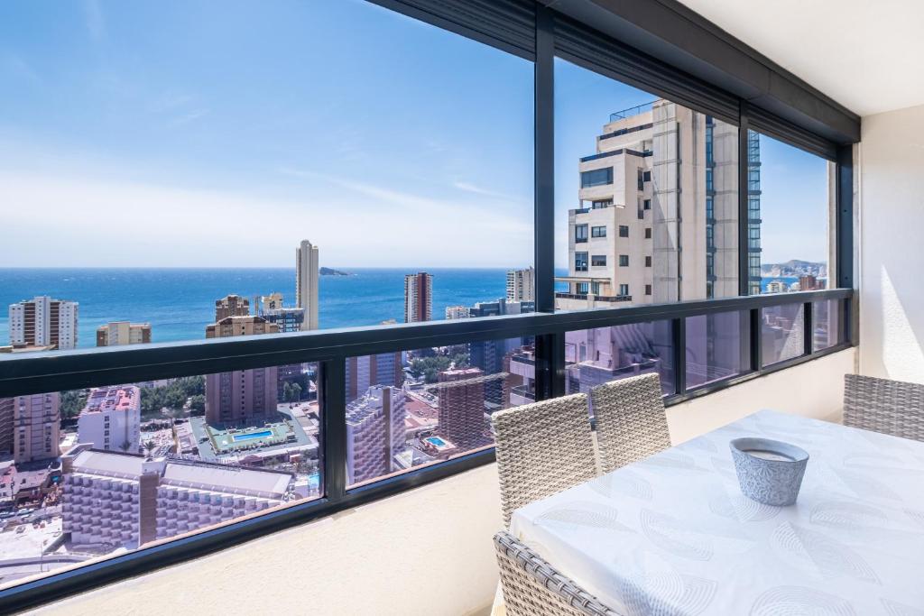 een balkon met een tafel en uitzicht op de oceaan bij Gemelos 26 Resort Apartment 27C Levante Beach in Benidorm