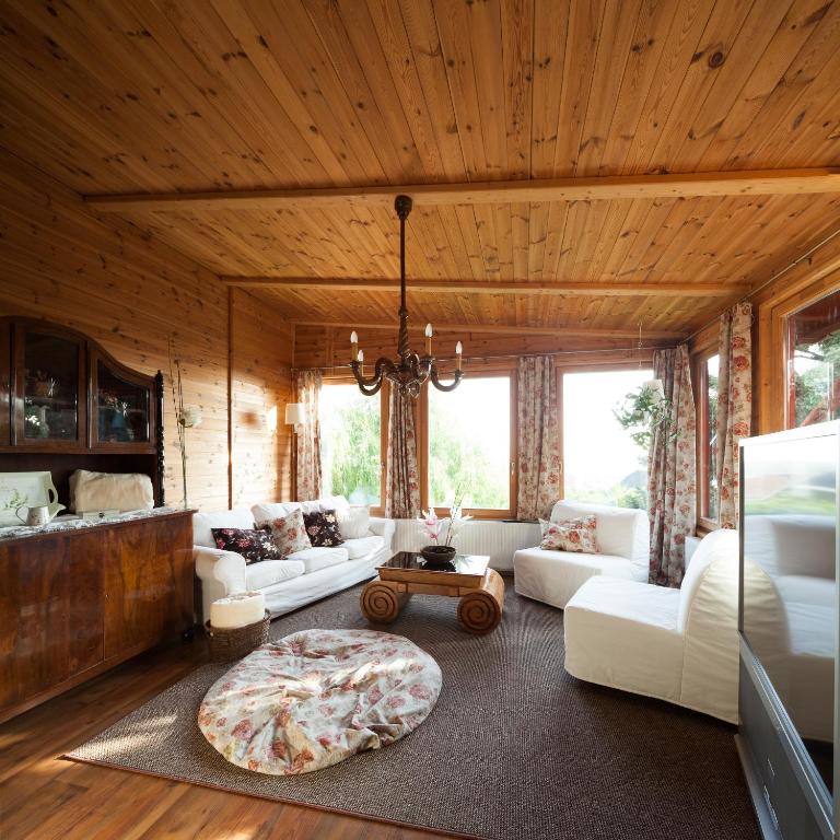 salon z białymi kanapami i drewnianym sufitem w obiekcie Apartment House 41 w mieście Sopron