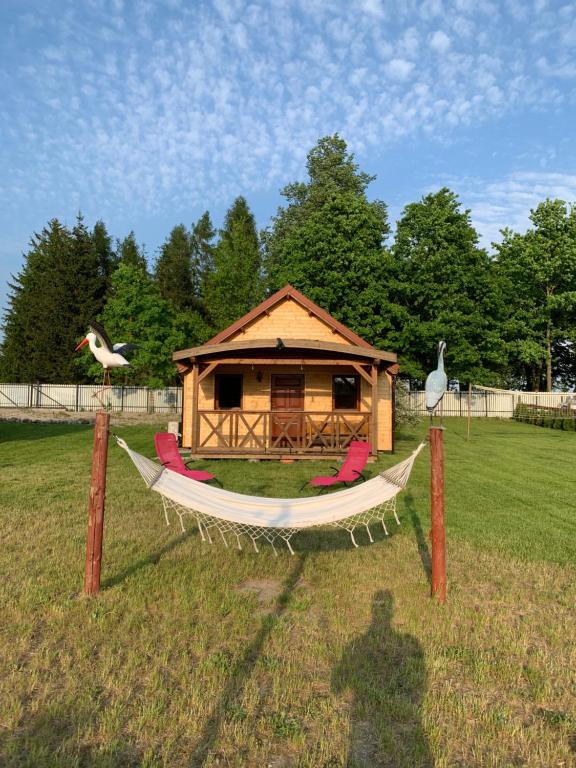 a gazebo with a hammock and a house at Domki u Wiesi in Giżycko