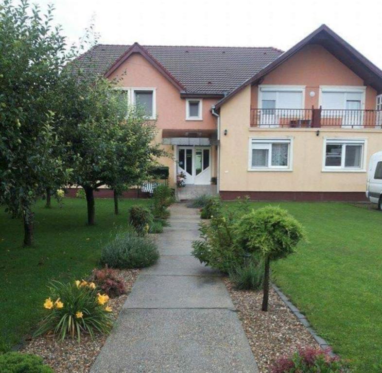 a house with a sidewalk in front of a yard at Pensiunea Coca in Baile Felix