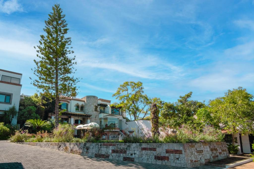 una casa con un árbol y una pared de piedra en Maja Hotel Boutique en Morelia