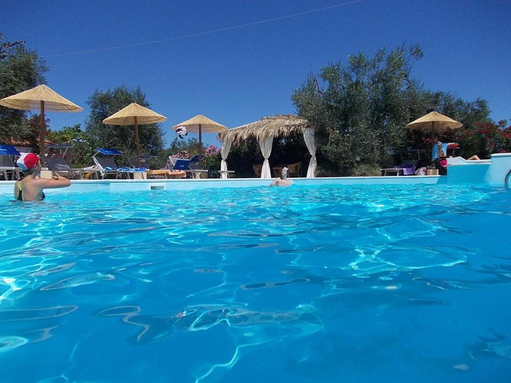 een zwembad met blauw water en parasols bij Casa Vacanze la Paloma in Peschici