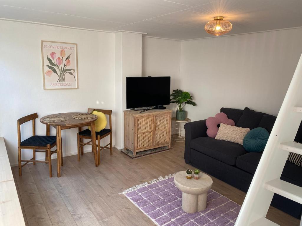una sala de estar con un sofá y una mesa en Beach Bliss, en Noordwijk