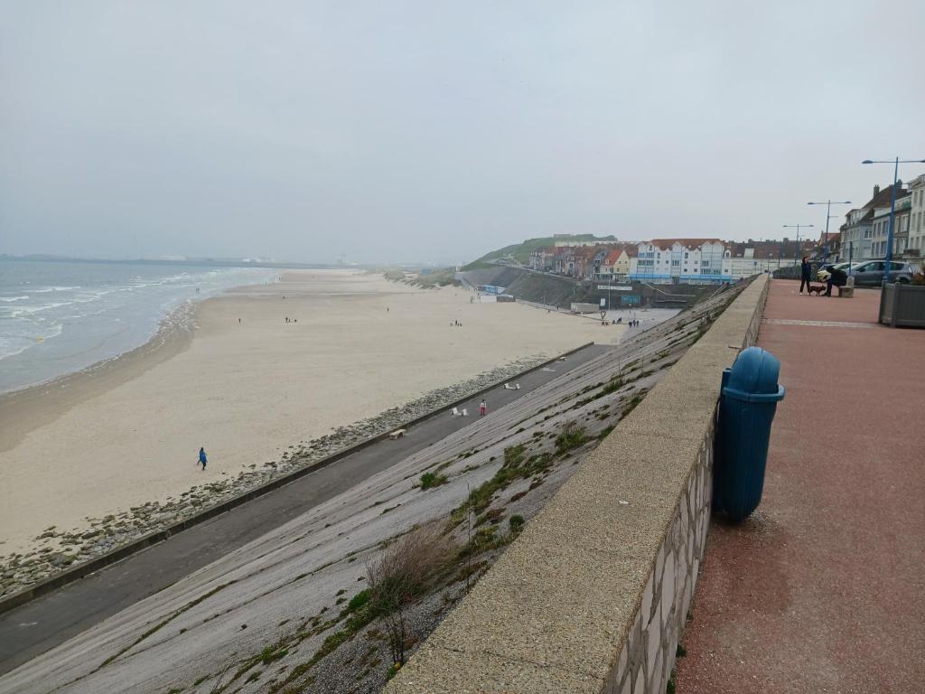 vistas a una playa con un cubo de basura azul en Mobil home F01 en Le Portel