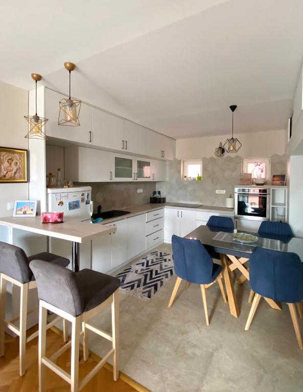 Apartman Kovacevic في بار: مطبخ مع طاولة وبعض الكراسي الزرقاء