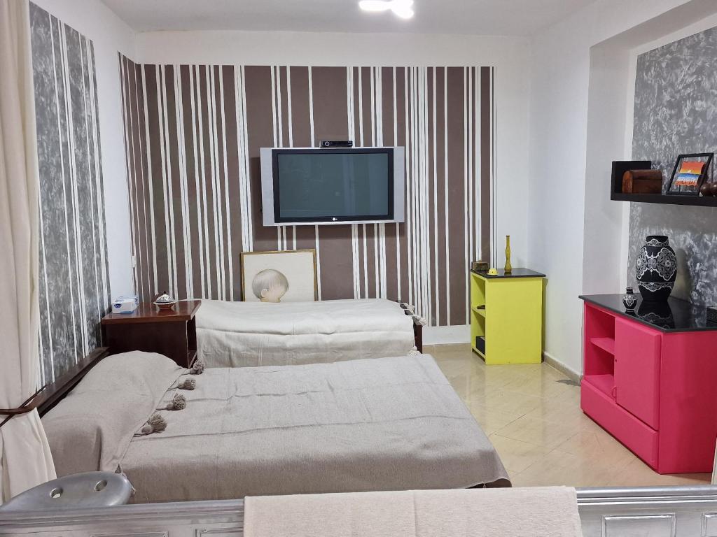 a living room with two beds and a flat screen tv at Azla beach in Azla