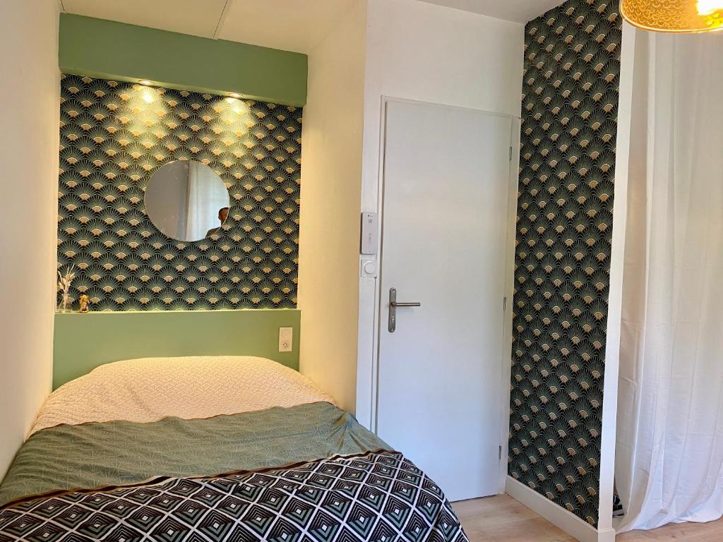 - une chambre avec un lit et un miroir mural dans l'établissement Studio tout juste rénové, à Dijon