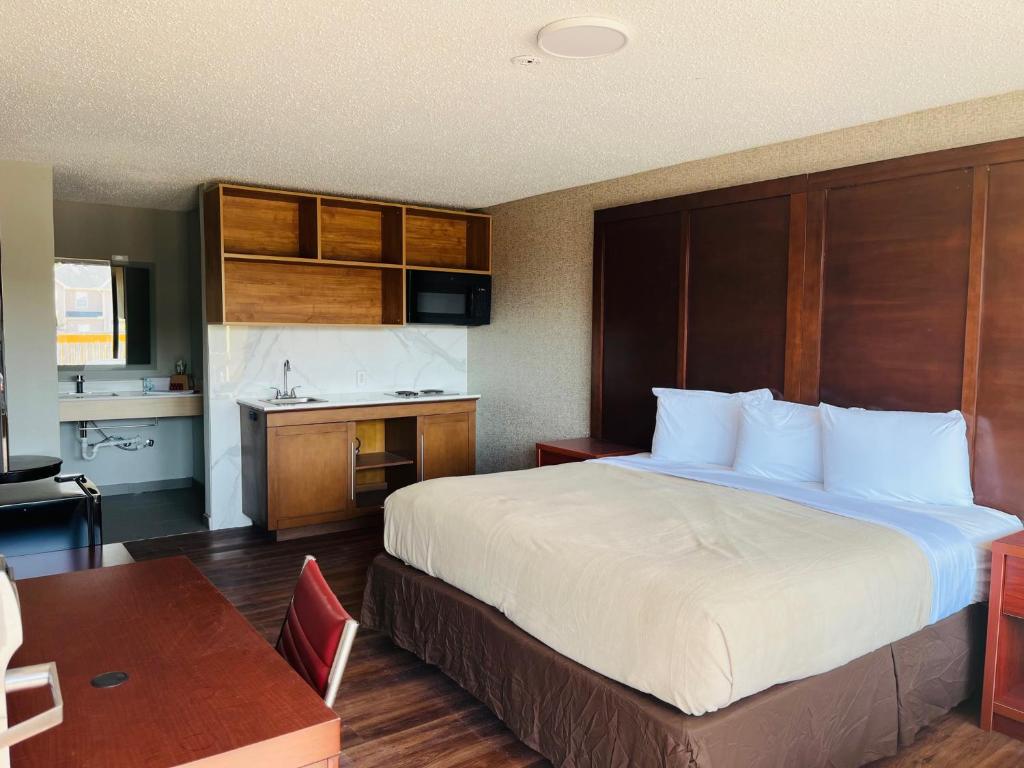 Una habitación de hotel con una cama grande y una cocina. en North Villa extended stay, en Houston