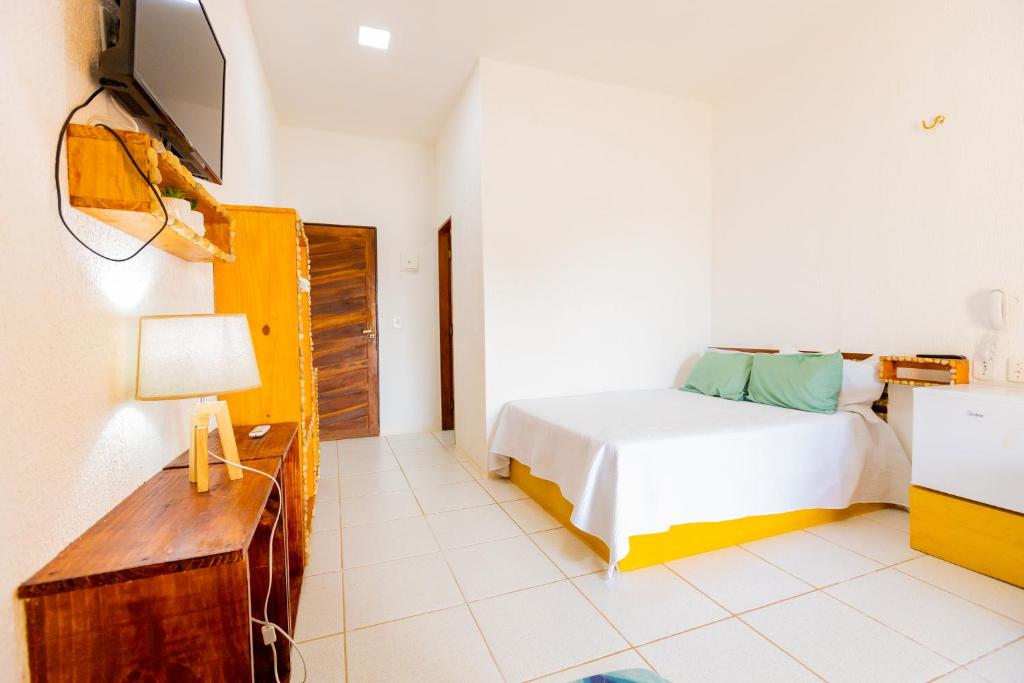 a bedroom with a bed and a tv on a wall at OYO Hotel Das Pedras in Parnaíba