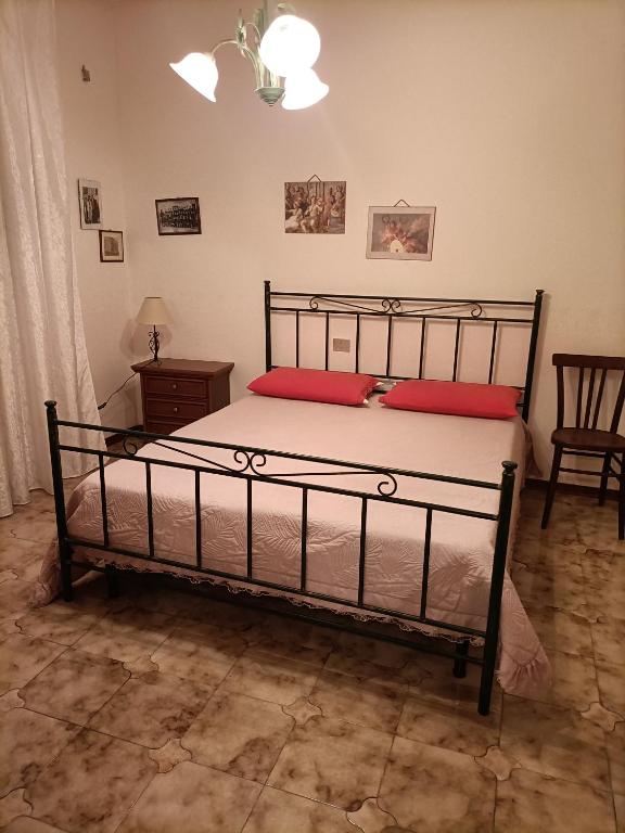 een slaapkamer met een bed met 2 rode kussens bij Nurachi vacanza in Nurachi