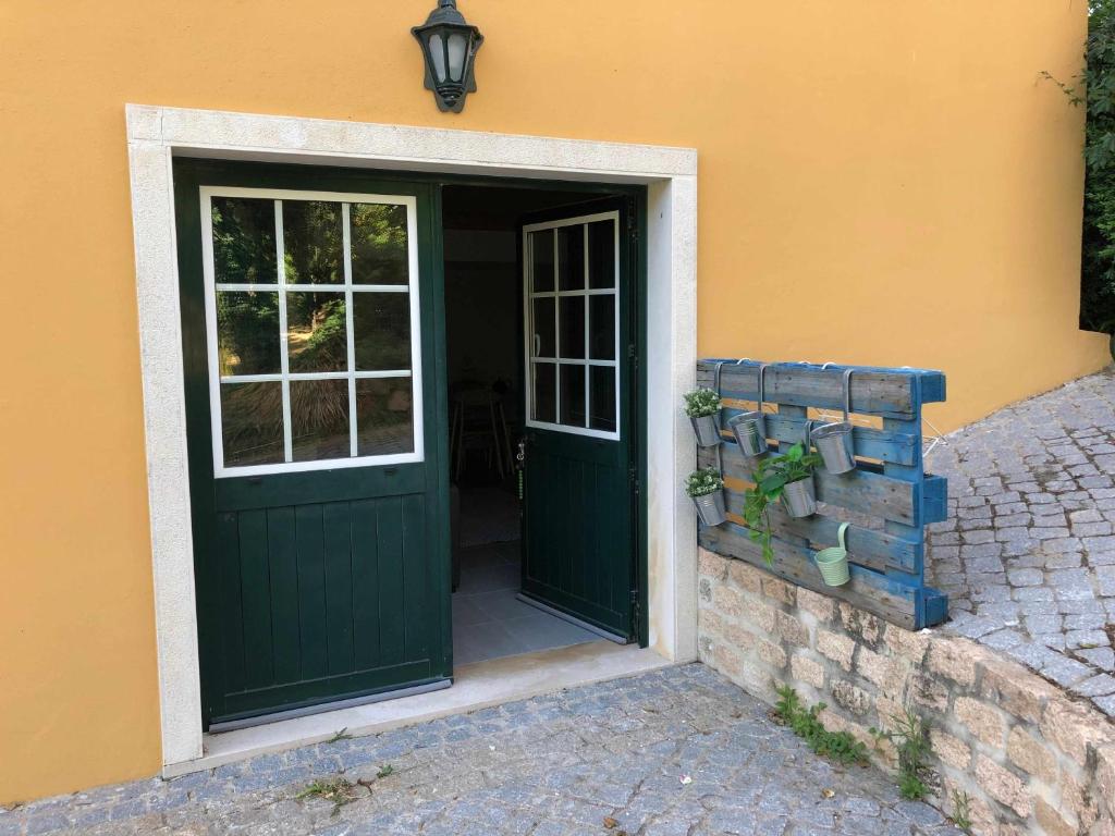 a green door with a window on a house at Quinta do Casal da Bica 
