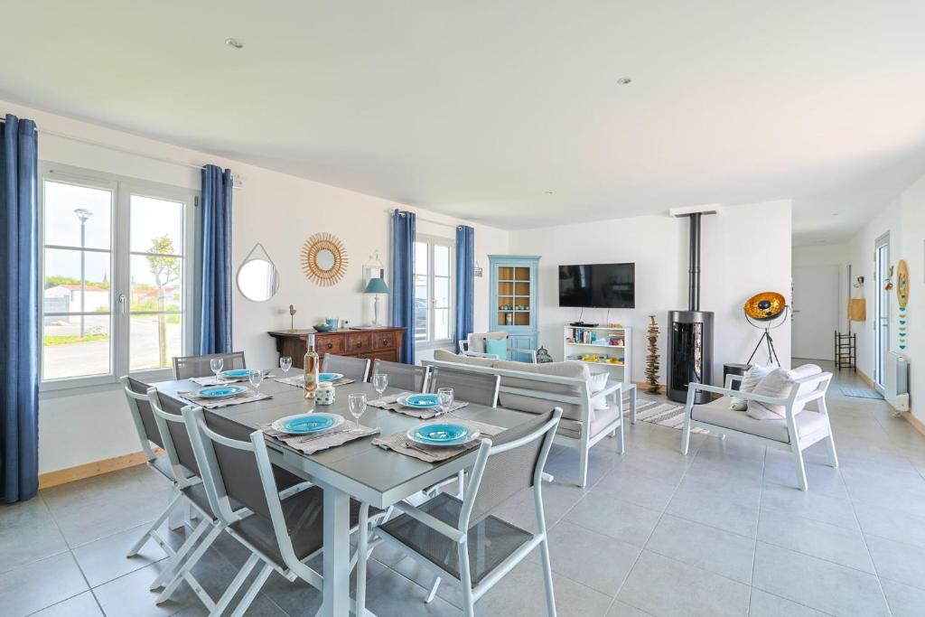 a dining room and living room with a table and chairs at Magnificent Villa recent quiet St Denis D'Oléron in Saint-Denis-dʼOléron