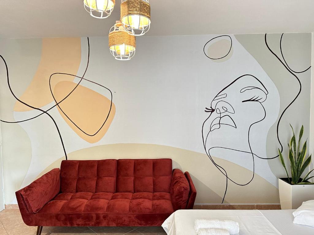 ein Wohnzimmer mit einem roten Sofa und einem Gemälde an der Wand in der Unterkunft Family Apartment Durres in Durrës