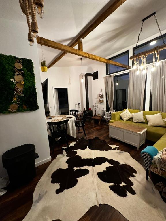 阿爾杰什的住宿－Casuta Nest，一间客厅,地板上设有牛地毯
