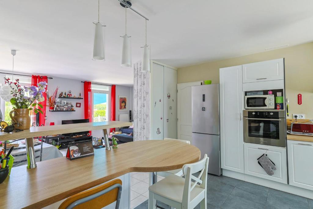 eine Küche mit weißen Schränken und einem Holztisch in der Unterkunft "Logis Debussy"- Saintes in Saintes