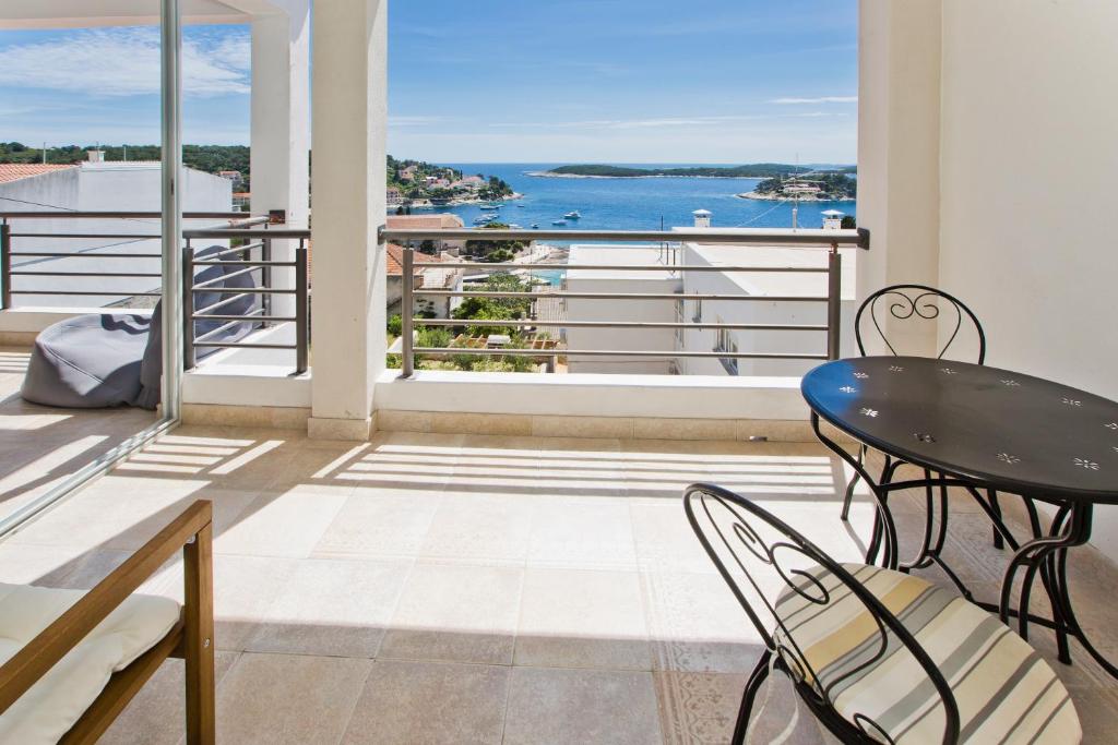 a balcony with a table and chairs and a view of the water at Rino in Hvar