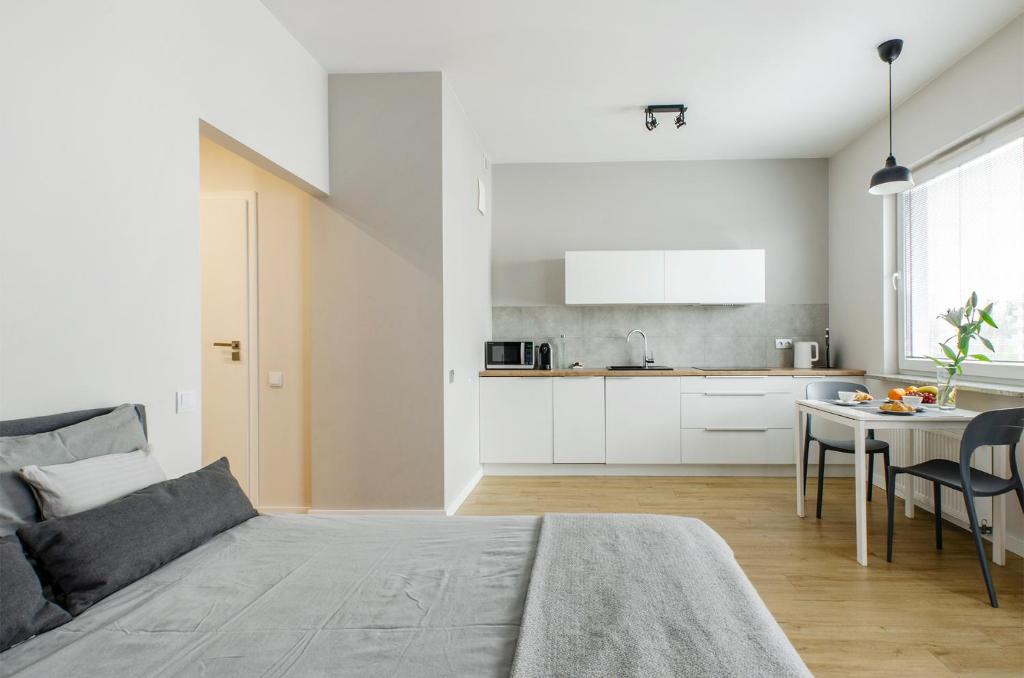 a living room with a bed and a kitchen at Apartament Majowy in Łódź