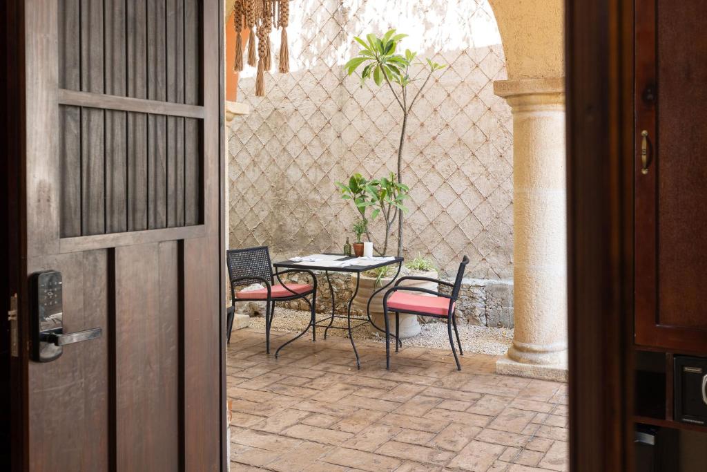 a patio with a table and chairs in a courtyard at Casa Dos Lirios Hotel Boutique in Mérida