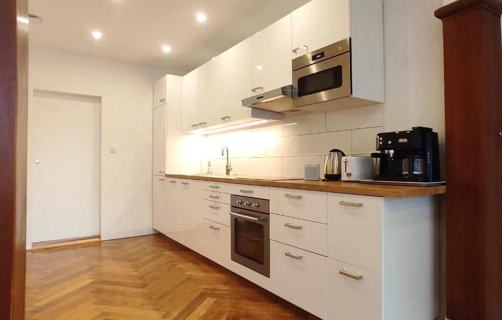 リクヴィールにあるGîte La Jouvence - Cœur de Riquewihr - 2-4 personnesの白いキャビネットと電子レンジを備えたキッチン