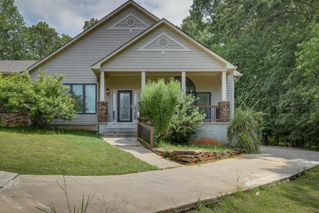 une petite maison avec une terrasse couverte et une allée. dans l'établissement Single-Story Home about 7 Mi to Old Towne Conyers!, à Conyers