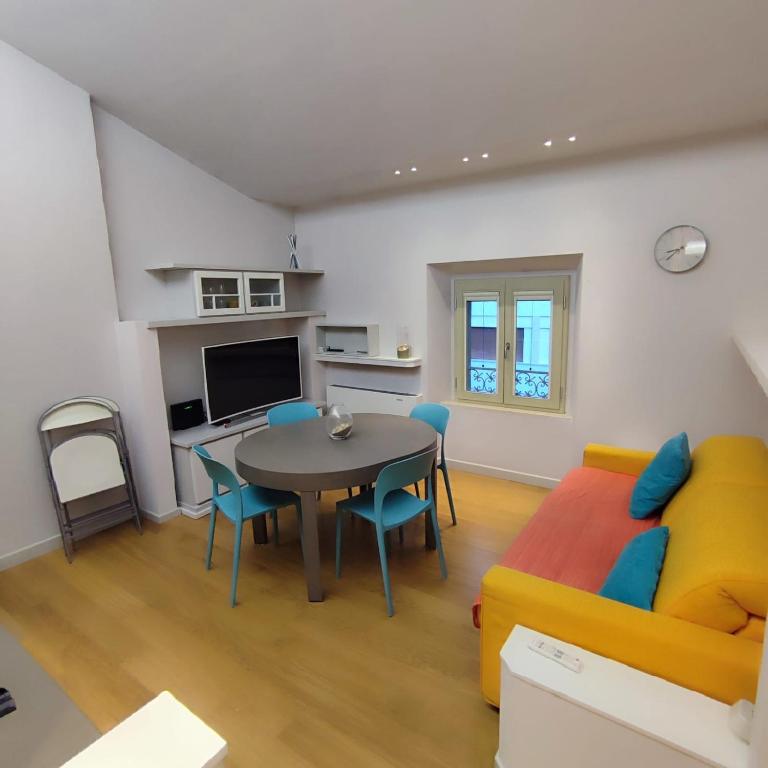 ein Wohnzimmer mit einem Tisch und einem Sofa in der Unterkunft GIOIA SEA Apartment In Versilia in Viareggio