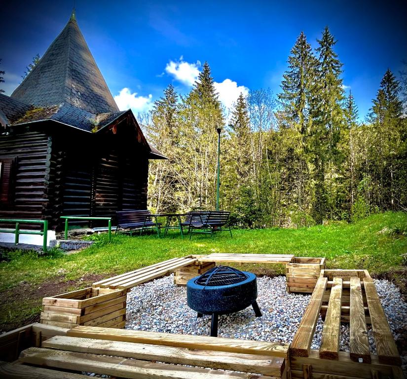 a backyard with a fire pit and a log cabin at chata REINA in Pusté Pole