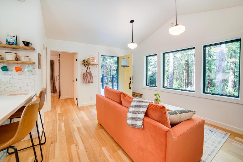 ein Wohnzimmer mit einem orangenen Sofa und einem Tisch in der Unterkunft Peaceful Mendocino Cottage Surrounded By Redwoods in Mendocino