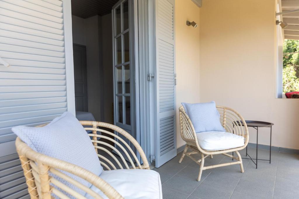 two wicker chairs and a table on a porch at Paleokastritsa Red Gate Flat in Paleokastritsa