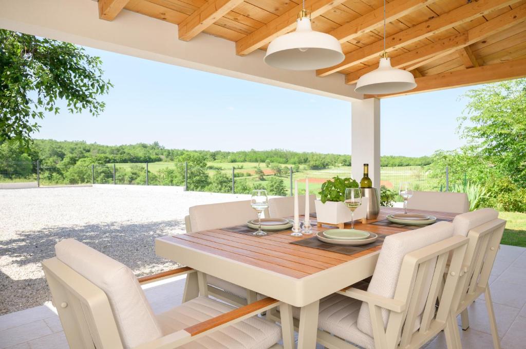 una sala da pranzo con tavolo e sedie in legno di Holiday home Country retreat a Višnjan (Visignano)