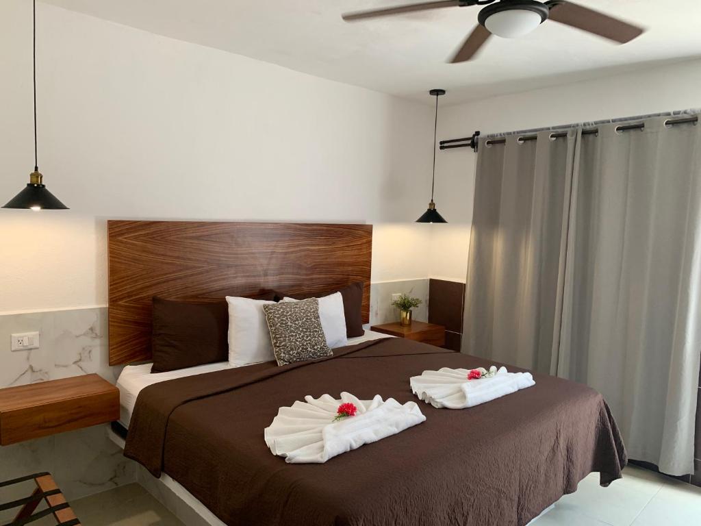 a bedroom with a bed with two towels on it at Hotel La Casa del Capi in Holbox Island