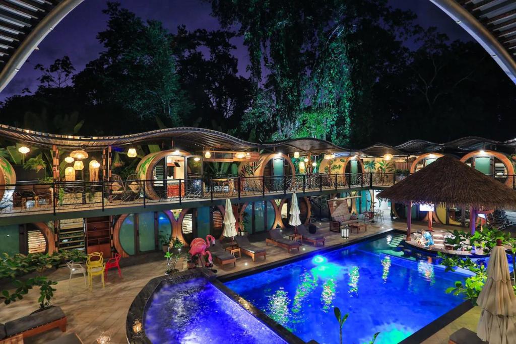 a resort with a swimming pool at night at Saranda Boutique Hotel in Puerto Viejo