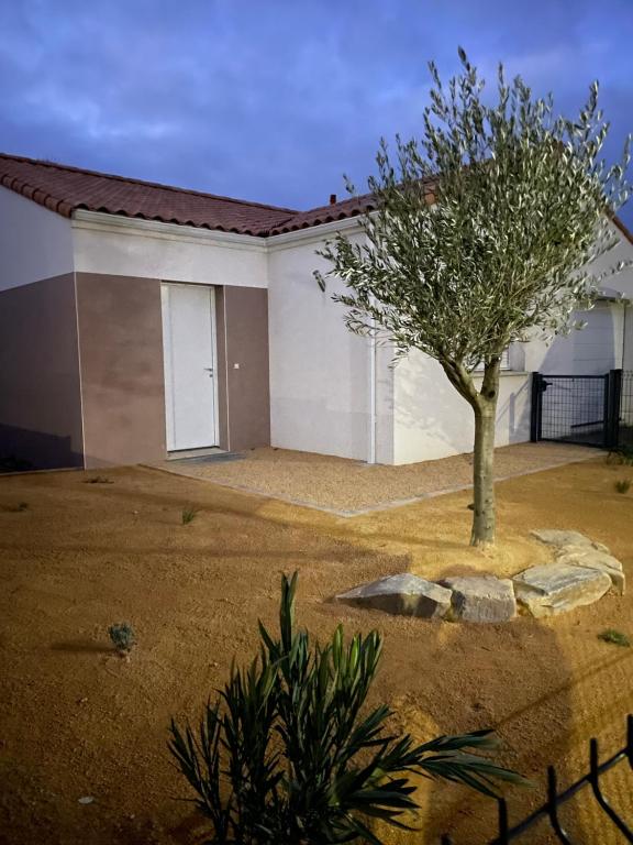 une maison avec un arbre devant dans l'établissement La Villa des Amarelles à Pornic - labellisée 3*, à Pornic