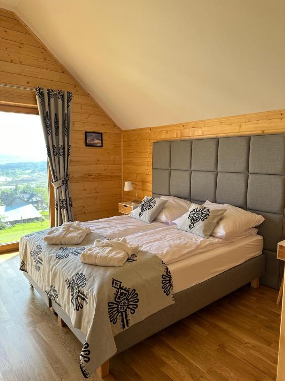 een slaapkamer met een groot bed en een groot raam bij Hyrna Chata Relaks&SPA in Maniowy