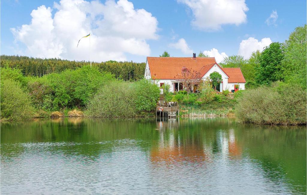 a house sitting on the side of a lake at Awesome Home In Genarp With Wifi in Genarp