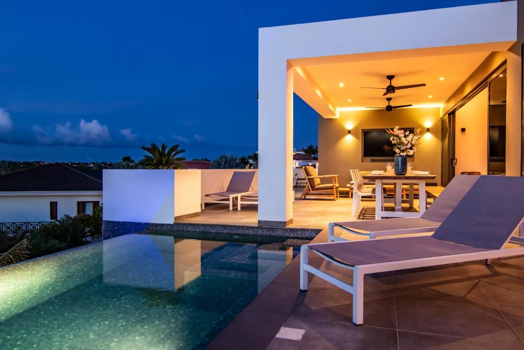 Villa con piscina por la noche en Ocean Sunset Villa luxury stay max. 14 people, en Dorp Sint Michiel