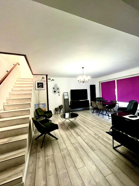 a living room with a staircase and a dining room at Duplex lux - Thoria in Bucharest
