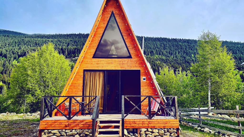 Casa pequeña con techo triangular y porche en Cozy chalet in Mestia, en Mestia