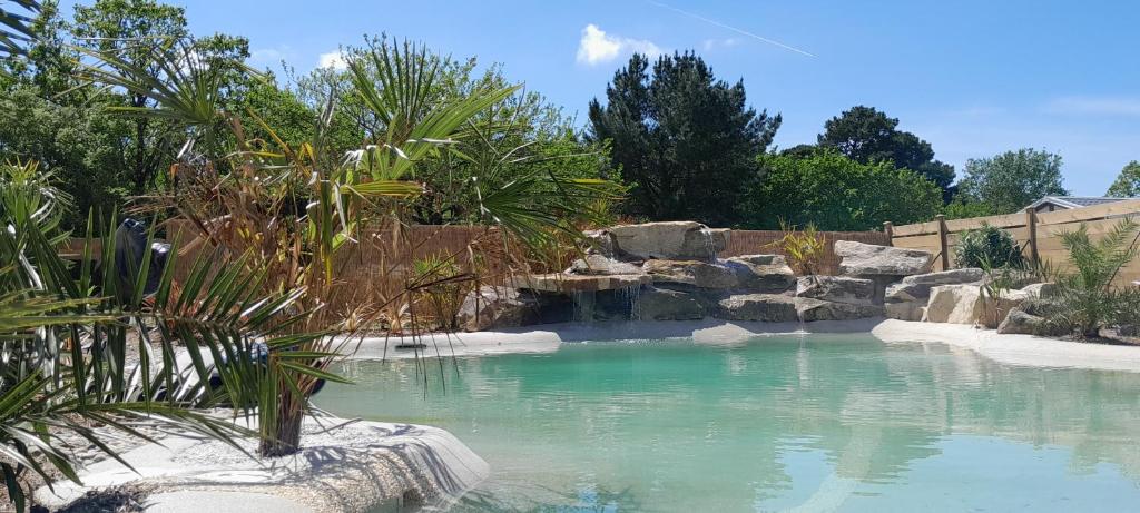 a pool of water with rocks in a yard at Camping Paradis d'Arvor in Ambon